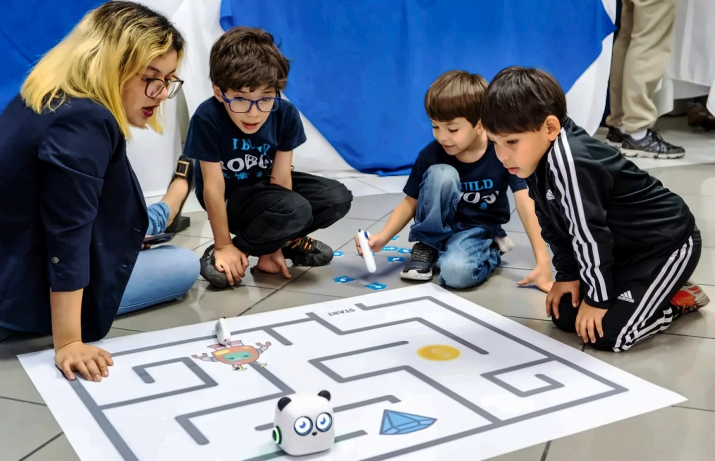 Niños y su docente programan un robot para resolver un reto de laberinto