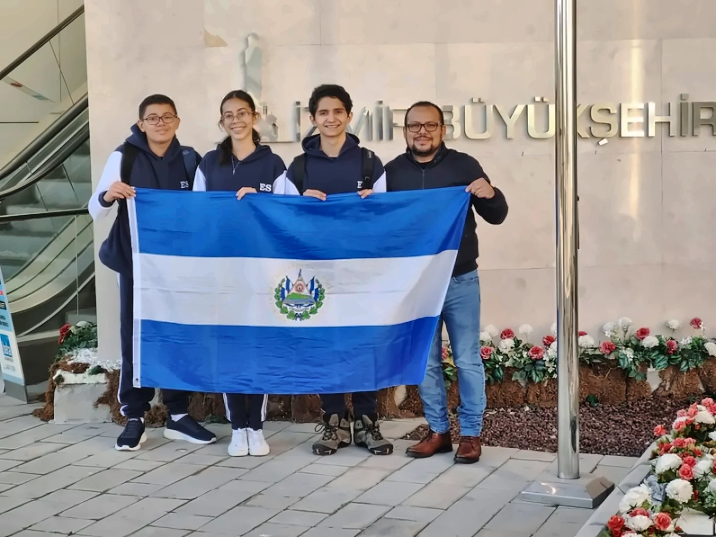 Team Green Force con la bandera de El Salvador en İzmir, Türkiye, durante la World Robot Olympiad 2024